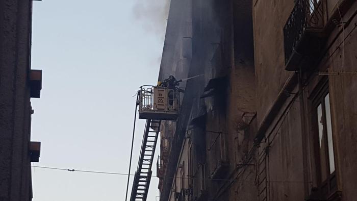 Vigili del fuoco al lavoro sull'incendio che si è sviluppato in un appartamento di uno stabile nel centro storico di Cosenza, 18 agosto 2017.