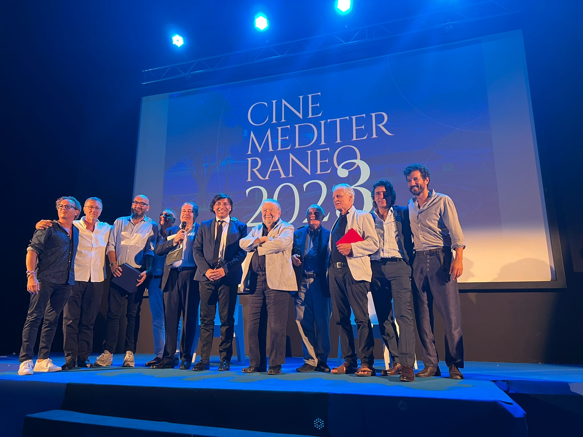 Belle giornate di cinema al Festival CineMediterraneo 2022, sostenuto dalla Calabria Film Commission, che si è concluso ieri sera a San Nicola Arcella. Giornate di incontri che hanno certificato il lavoro sul campo e le relazioni positive della Fondazione con le importanti figure presenti: dai registi, Pupi Avati, Michele Placido, Francesco Costabile, Giorgio Verdelli e Gianluca Ansanelli; alle attrici Laura Morante ed Isabella Ferrari, gli attori Adriano Giannini e Francesco Scianna, lo sceneggiatore Nicola Guaglianone. Tutti concordi nell’evidenziare il ruolo forte della Film Commission, dal supporto alle produzioni, fino al sostegno alle tante manifestazioni (19 tra Festival e Rassegne) che animano la lunga estate 2022 della Calabria. Eco positiva raccolta con favore dal Commissario straordinario Anton Giulio Grande che, nel corso delle serate incorniciate dalla bellezza paesaggistica di San Nicola Arcella, ha premiato Laura Morante, Alessandro Preziosi ed Isabella Ferrari, con motivazioni culturali solide, relative alla carriera degli artisti e alla loro storia professionale. Ieri sera la fotografia finale sul palco del Festival, che rappresenta una bella immagine per il cinema italiano e per i tanti progetti della Calabria Film Commission.